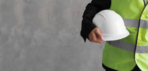 istock Close-up workwear and helmet in engineer or constructor hand as safety uniform isolated on grey background. Banner 1414786184