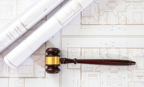 istock Labor, Construction law. Judge gavel on building blueprint plans, overhead 1414792198