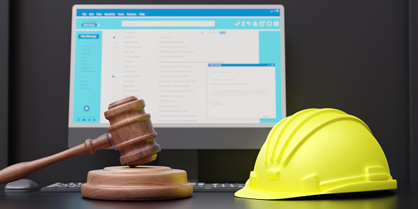 Labor, Construction lawyer. Yellow safety hardhat, judge gavel and computer laptop on a table, close up. 3d render