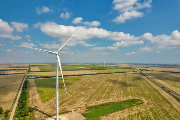 istock Drone view over wind farm turbine closeup against blue sky. 1414792976