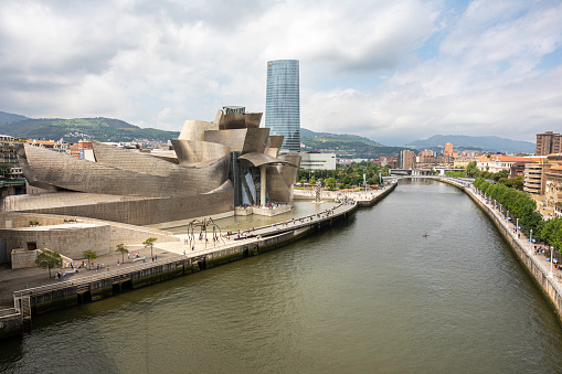Over looking the Nervion River and the Bilbao skyline from the La Salve Bridge. On the right side of the river is traditional Bilbao and on the left are modern buildings of the city with the Guggenheim museum and Iberdrola tower.
