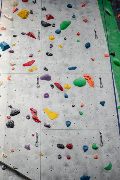 istock Rock climbing wall with climbing holds in gym 1414796054