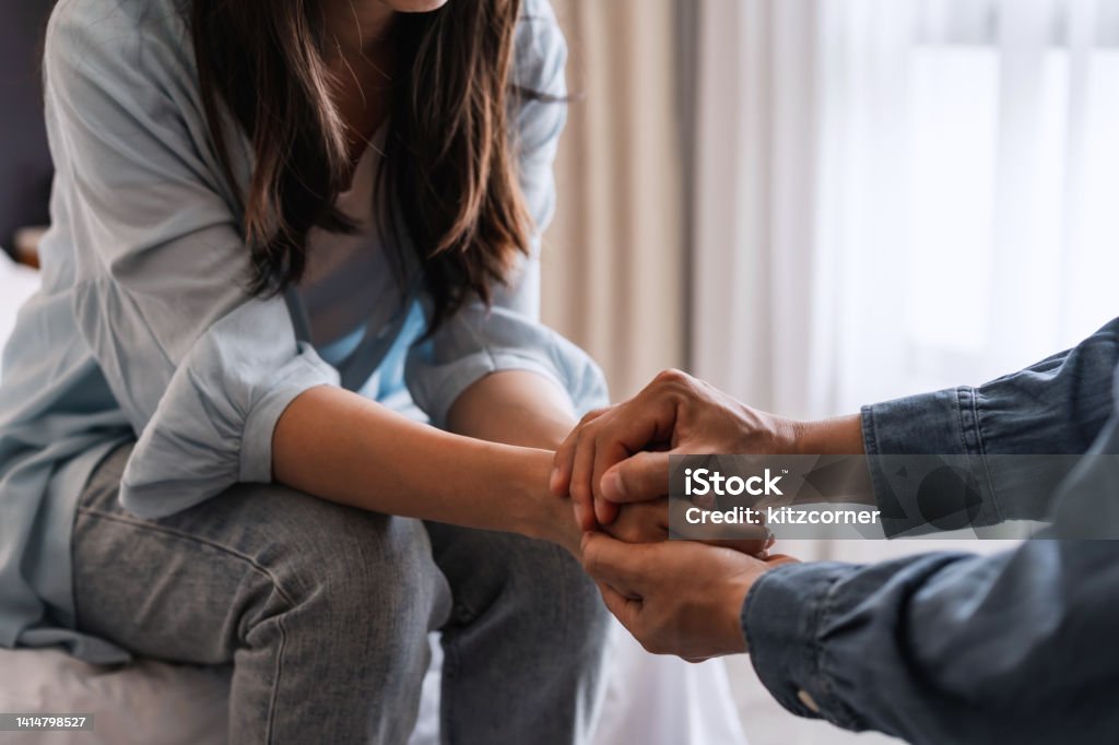Young man comforting and supporting a sad woman who is in serious trouble at home, Consolation and encouragement concept Couple - Relationship Stock Photo