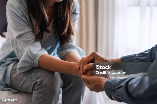 Young Man Comforting And Supporting A Sad Woman Who Is In Serious Trouble At Home Consolation And Encouragement Concept Stock Photo - Download Image Now