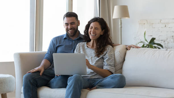 istock Happy overjoyed millennial couple using laptop at home together 1414798656