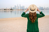 Young woman on the beach overlooking Dubai skyline