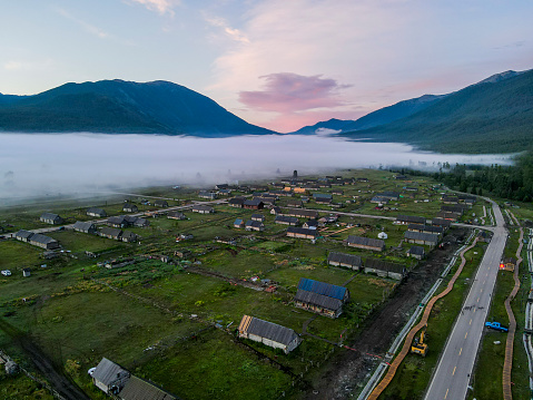 The misty fog flowing over the village in Kanas Lake Park in Xinjiang Province, China