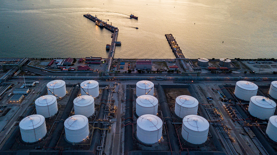 Aerial view oil tertminal storage tank, White oil tank storage chemical petroleum petrochemical refinery product at oil terminal, Business commercial trade fuel and energy transport by tanker ship vessel.