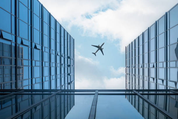 istock Airplane flying over modern glass building 1414806040