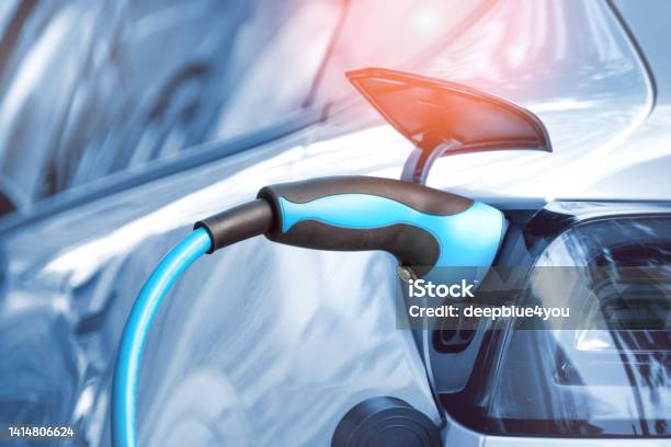 Electric Car Is Connected To A Charging Station With A Power Cord Stock Photo - Download Image Now
