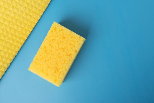 istock cleaning service, disinfection,yellow sponge and rag on blue background 1414806885