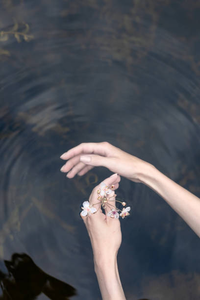 istock Young woman's hand touching the water in the sea 1414808652