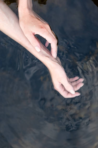 istock girl touch water, closeup view 1414808661