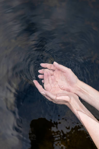 istock girl touch water, closeup view 1414808741