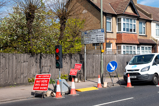 Work being carried out by Thames Water in Beckenham, Kent (London Borough of Bromley), involving repairs to both the pavement and the road. Pedestrians are being advised to cross the road to the other pavement and temporary traffic lights are in use as one lane of the road is closed.