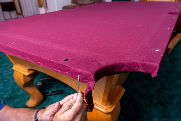 Professional removes staples from the felt on a pool table stock photo
