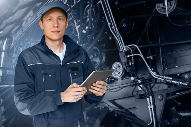 istock Serviceman with digital tablet on a background of the tractor 1414811078