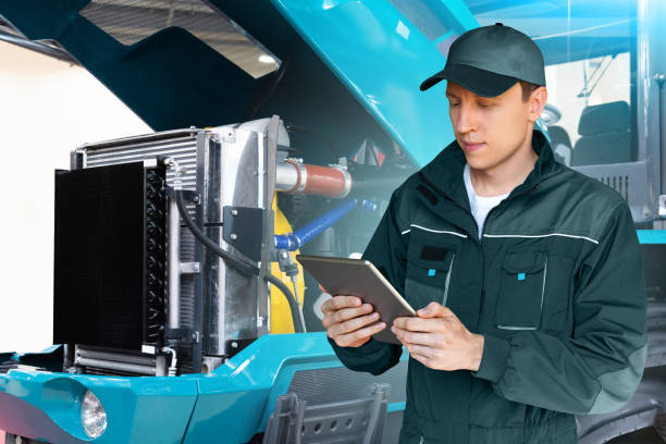 istock Serviceman with digital tablet on a background of the tractor 1414811123