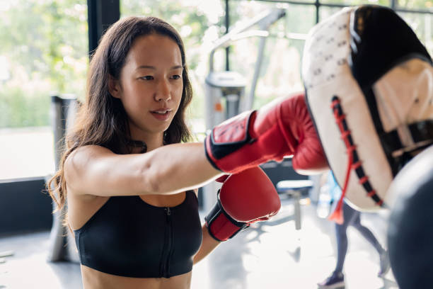 istock Young woman doing boxing training with her coach. 1414817386