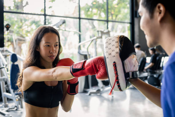 istock Young woman doing boxing training with her coach. 1414817392