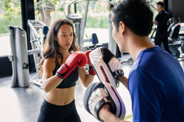 istock Young woman doing boxing training with her coach. 1414817418