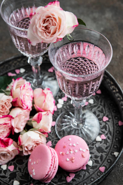istock Celebration background - two chrystal champagne glasses with roses bouquet 1414818528