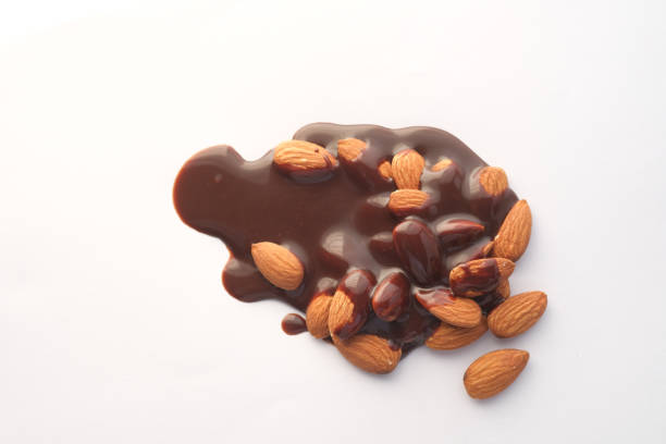 istock dark chocolate cream pouring on almond nut on white 1414818717