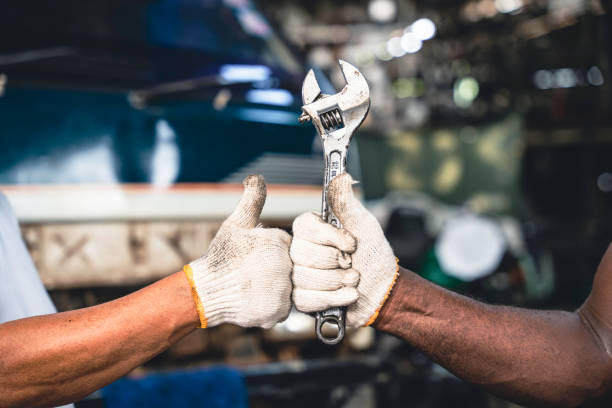 istock Fist and thumb up of two auto mechanic. 1414818861