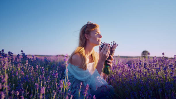 istock Looking for inner peace. Woman picking lavender and smelling flowers 1414823112