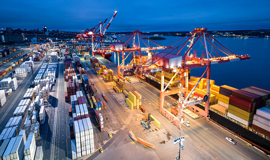 Aerial view of a container ship being loaded at night.