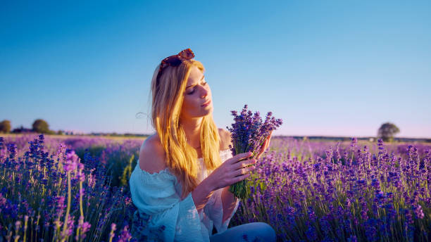 istock Looking for inner peace. Woman picking lavender and smelling flowers 1414823265