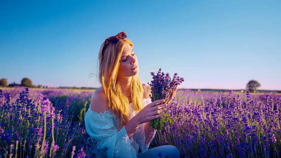 Woman making lavender bouquet. Picking fresh flowers and enjoying the smell