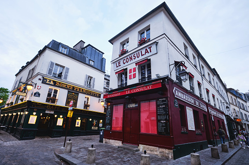 Paris, France - May, 2022: wide angle view of Le Consulat restaurant cafe in Montmartre hill in the evening on a cloudy day