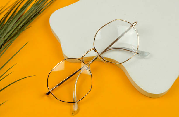 istock Stylish women's glasses in a gold-colored frame on a colored background 1414832205