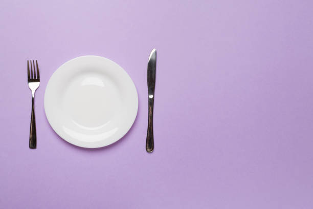 istock Empty dish with knife and fork on color background, top view 1414833506