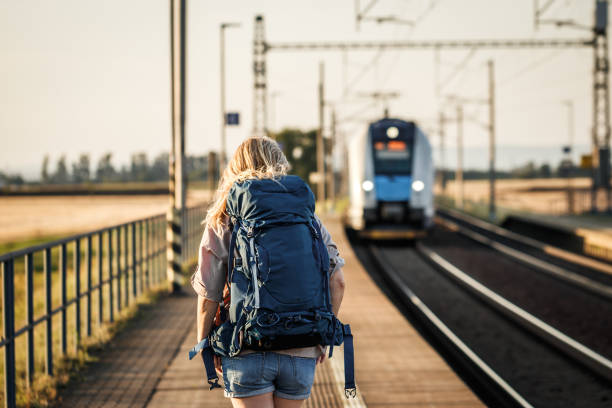 istock Traveler with backpack looking at arriving train at railway station 1414833715