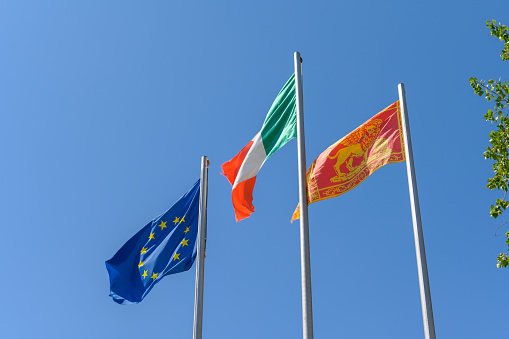 Set of flags fluttering in the wind against blue sky background