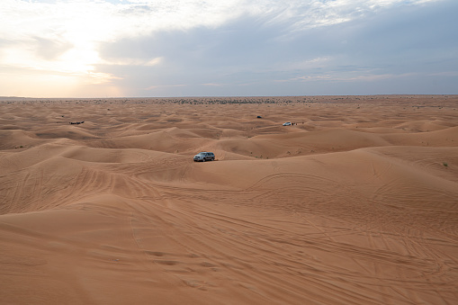 A large mixed group of tourist from a cruise ship docked in Bubai, UAE and the all-terrain vehicles gather in the desert west of the city for a sightseeing and cultural tour that will last into the night hours.  Image taken on April, 2012 and GPS coordinates are attached to the image if needed