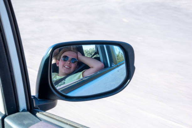 istock Reflection of happy child  in rear view mirror 1414842383