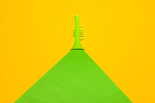 green trumpet with green wave cutting yellow background, creative art designs, press pause