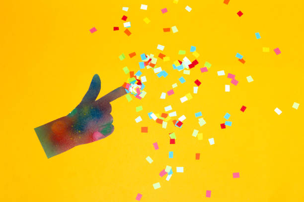 istock magic touch, creative art design on a yellow background, colorful hand with colorful paper scattered around 1414846673