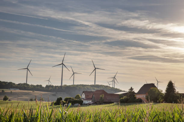 istock Wind turbines village field sky clouds 1414846776