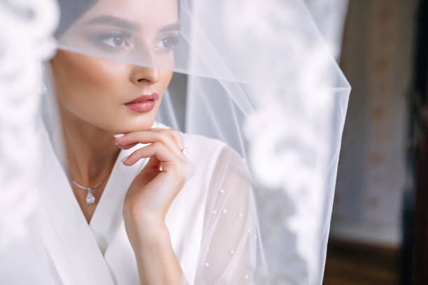 istock charming bride wrapped in a veil. Wedding morning. 1414847189