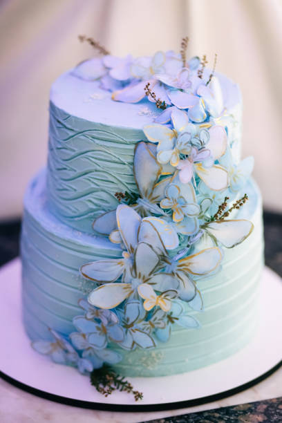 istock blue wedding cake with mastic butterflies on the table. Picture for a menu or a catalog of confectionery products. 1414847793
