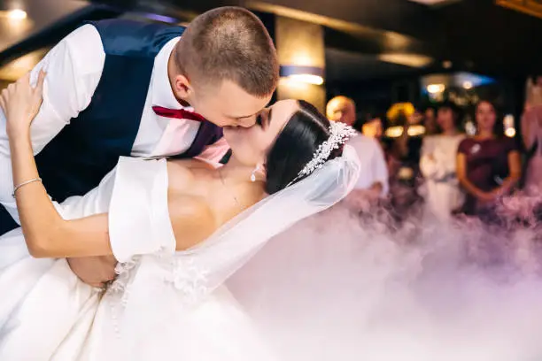 Bride and groom kiss each other tender after their first dance.