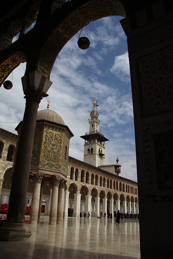 Damascus, Syria - March 20, 2011: People walk in the courtyard of the Umayyad Mosque. Built on the site of a Byzantine church in the 8th century, today it is one of the most beautiful architectural landmarks in Syria.
