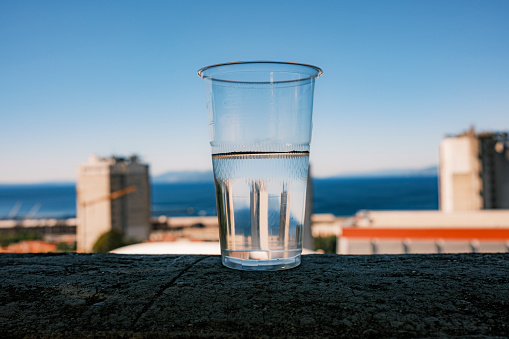 plastic glass of cold water on the terrace of the apartment with a view of the Adriatic Sea, summer, clear, sunny, Croatia