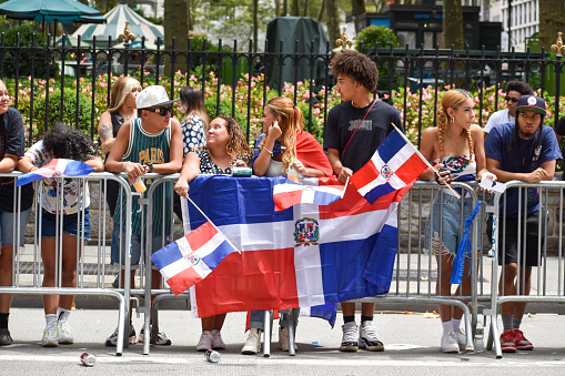 New Yorkers of all ages are seen wearing Dominican flag during the Dominican Day Parade on Sixth Avenue in New York City.