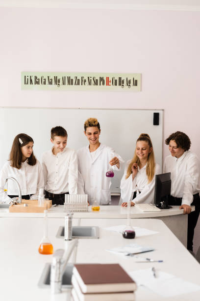 dyskusja z nauczycielem na lekcji chemii w laboratorium. grupa kolegów z klasy omawia eksperymenty chemiczne i prace domowe w szkole. koncepcja edukacji. - scholastic aptitude test zdjęcia i obrazy z banku zdjęć