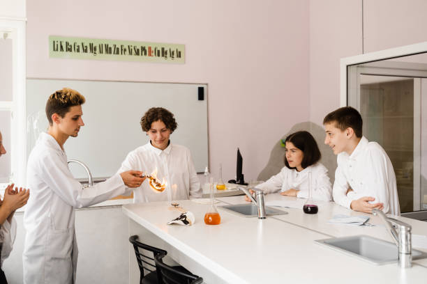 lekcja chemii w labaratorium. edukacja online w klasie z grupą uczniów uczących się na laptopie, uśmiechających się i bawiących razem. - scholastic aptitude test zdjęcia i obrazy z banku zdjęć